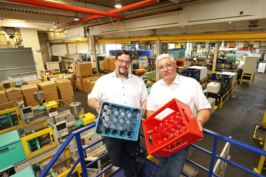 Johannes Lehmann (l.) und Joachim Lehmann mit Getränkekasten aus der Frör-Produktion. Weitere Geschäftsfelder sind Medizin- und Dünnwandtechnik, Montagen und Veredelungen.
